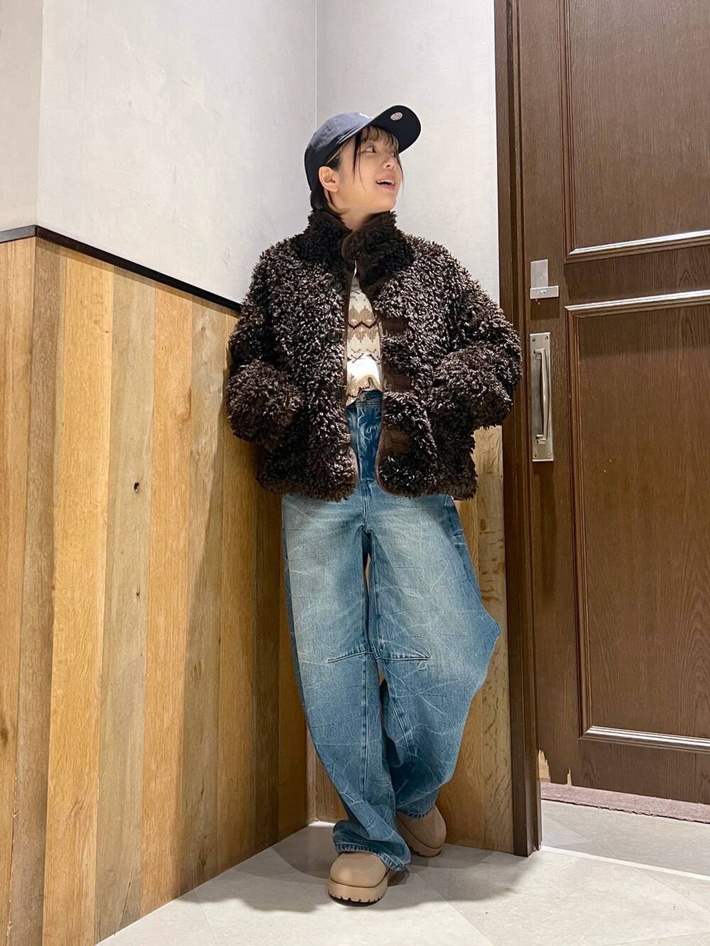 ホワイト系のニット/セーター、ブラウン系のブルゾン、ブルー系のデニムパンツを着用したレディースの秋コーディネートの5枚目の写真