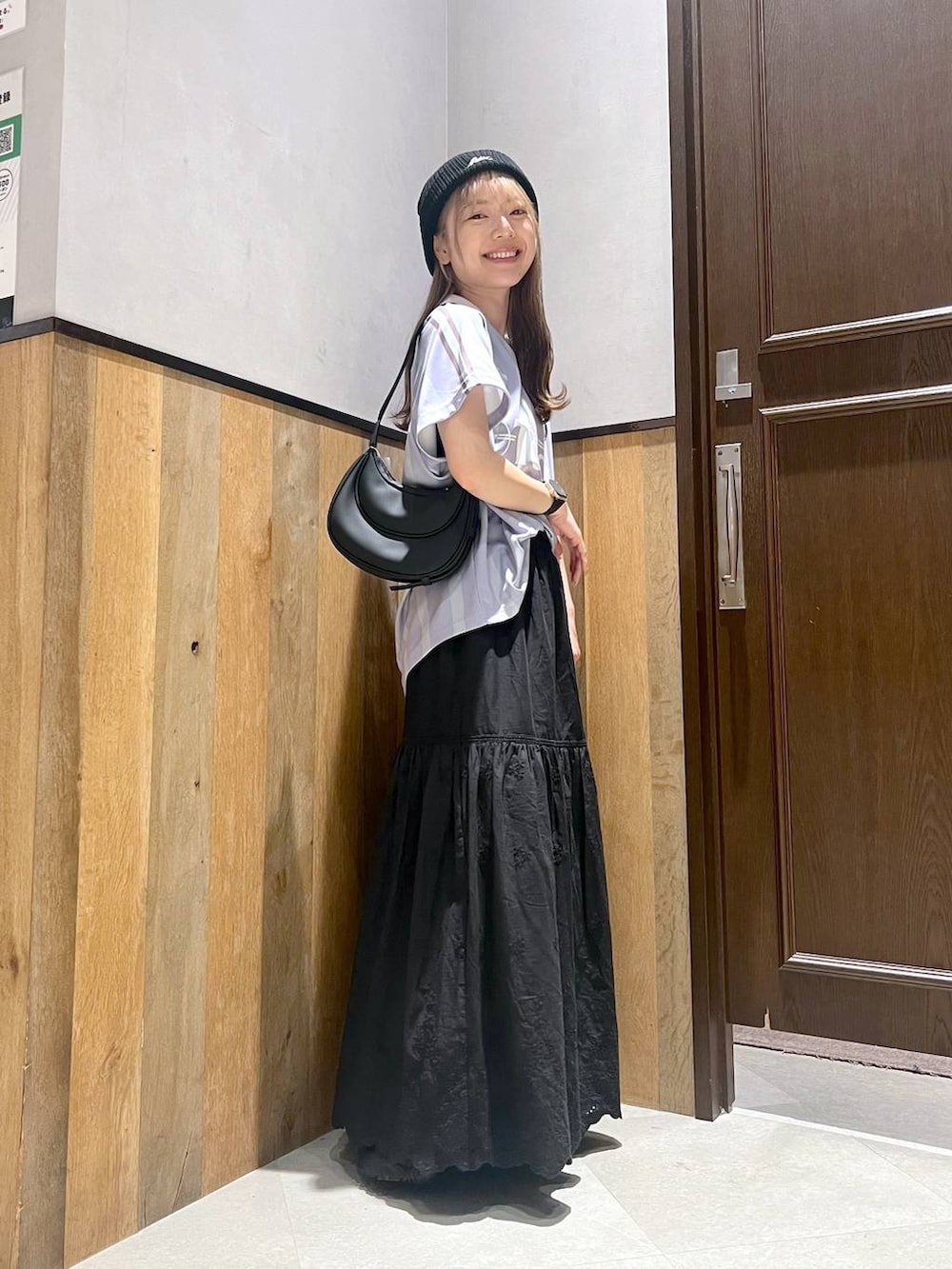 ブラック系のスカート、ブラック系のサンダル、ブルー系のTシャツ/カットソーを着用したレディースの夏コーディネートの2枚目の写真