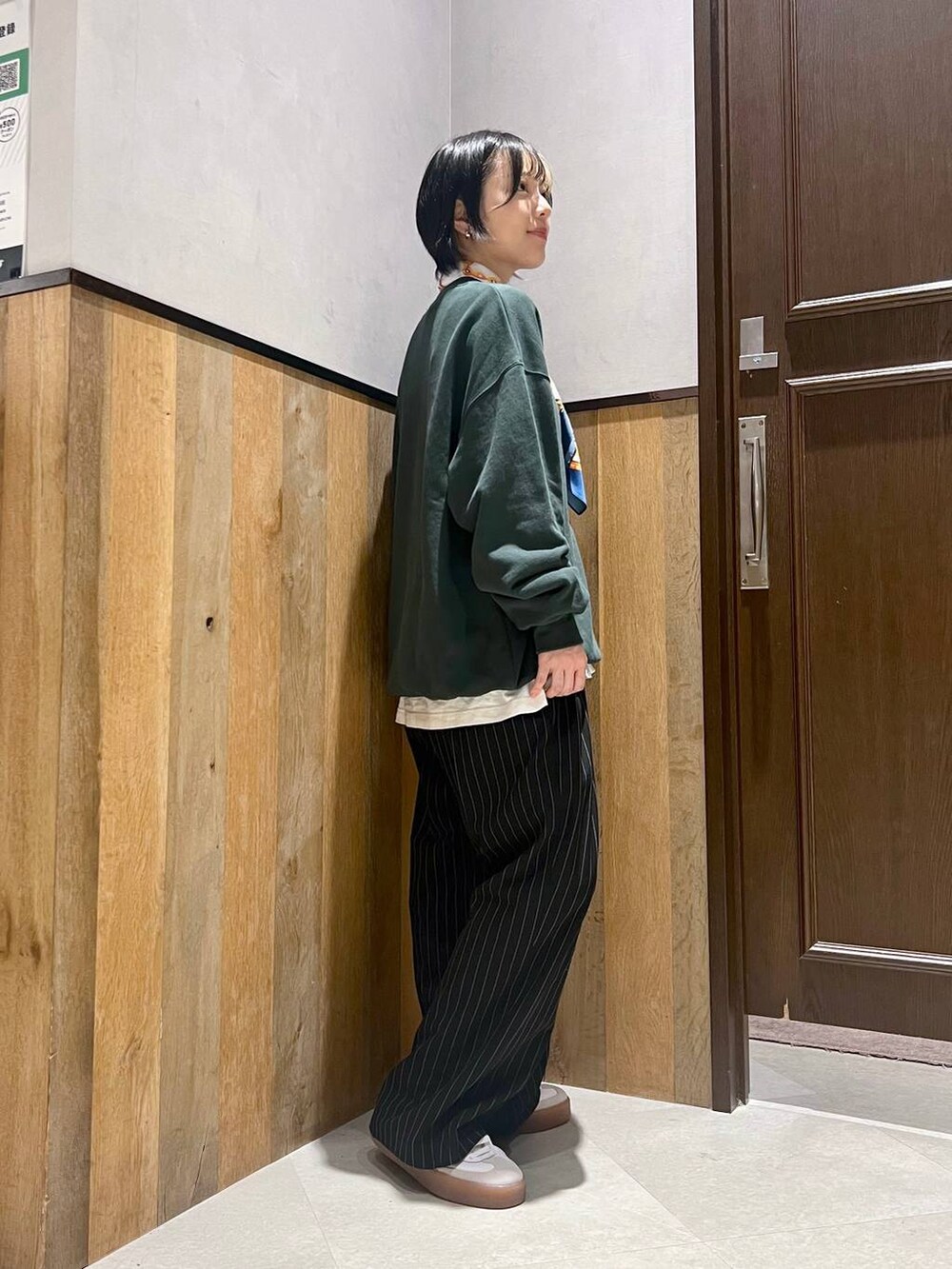 ブラック系のスラックス、ホワイト系のTシャツ/カットソー、グリーン系のスウェットを着用したレディースの秋コーディネートの2枚目の写真