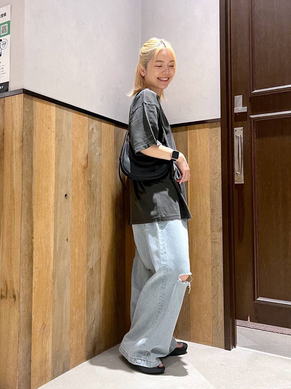 ブラック系のサンダル、ブルー系のデニムパンツ、ブラック系のショルダーバッグを着用したレディースの夏コーディネートの3枚目の写真