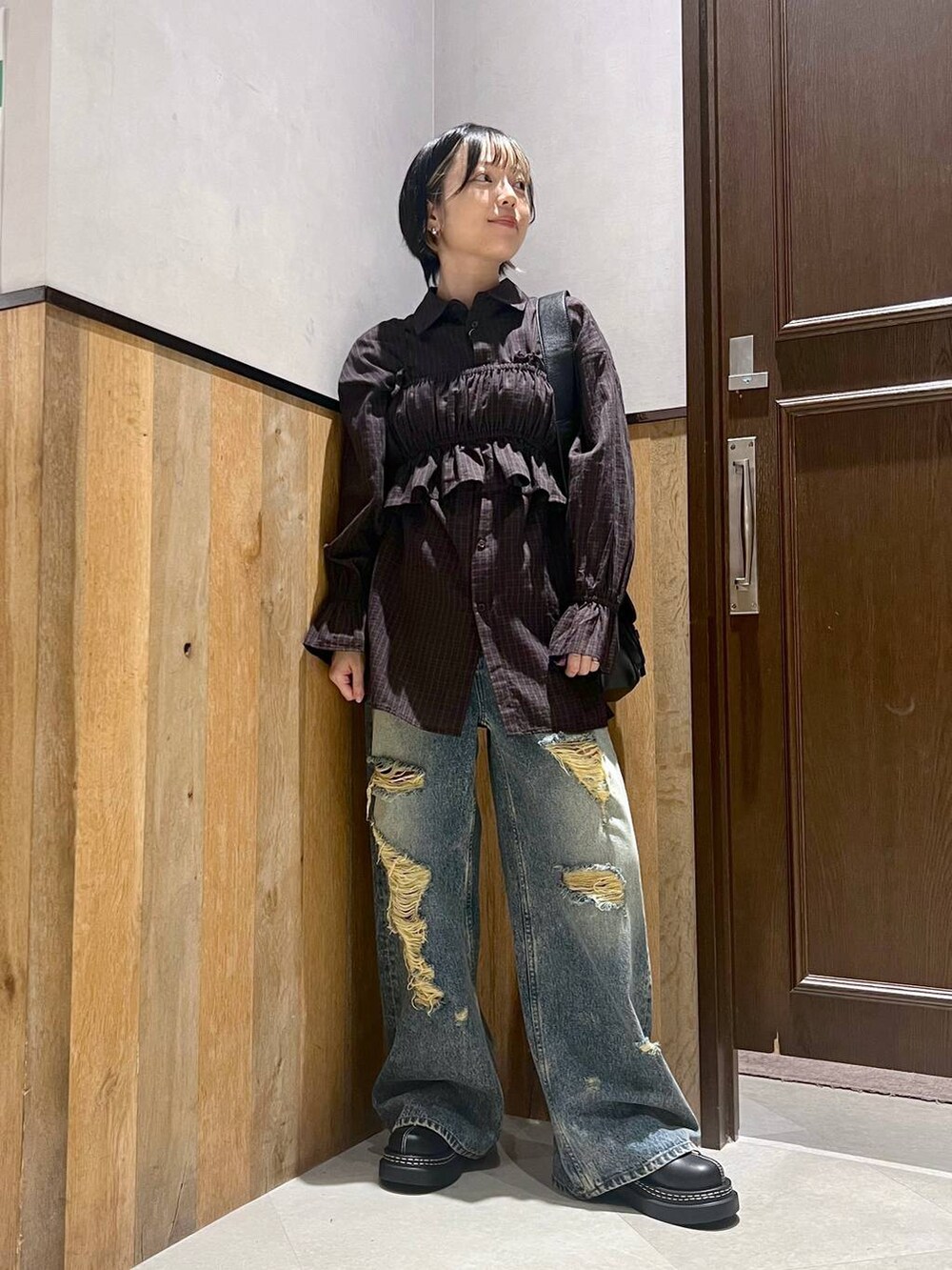 ブルー系のデニムパンツ、ブラック系のローファー、ブルー系のショルダーバッグを着用したレディースの秋コーディネートの2枚目の写真