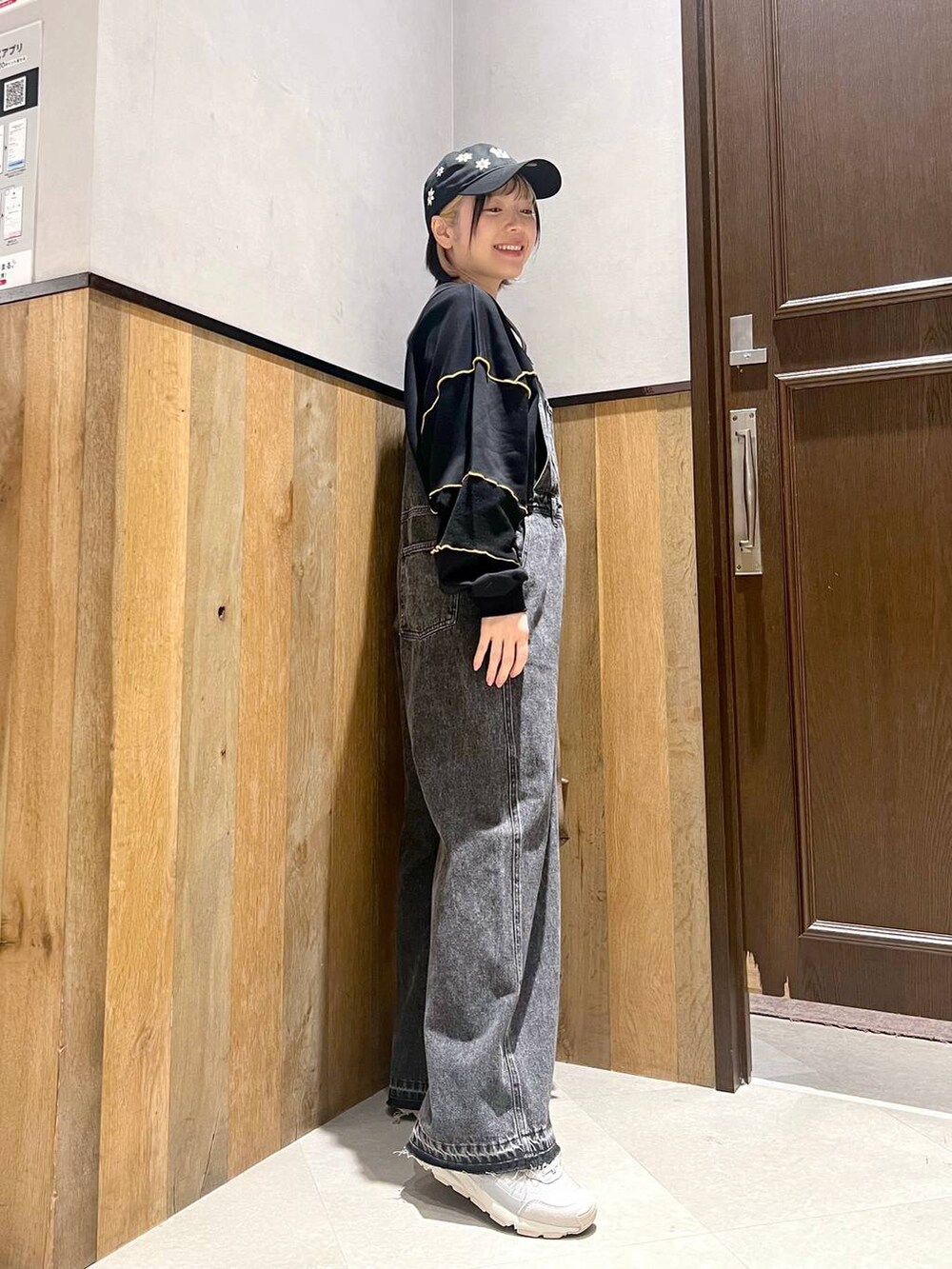 ブラック系のサロペット/オーバーオール、ブラック系のスウェット、グレー系のスニーカーを着用したレディースの秋コーディネートの2枚目の写真