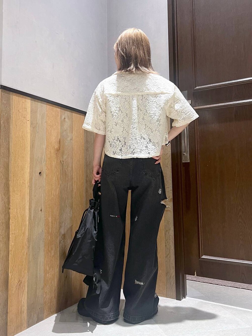 ブラック系のショルダーバッグ、ブラック系のスニーカー、ホワイト系のTシャツ/カットソーを着用したレディースの夏コーディネートの4枚目の写真