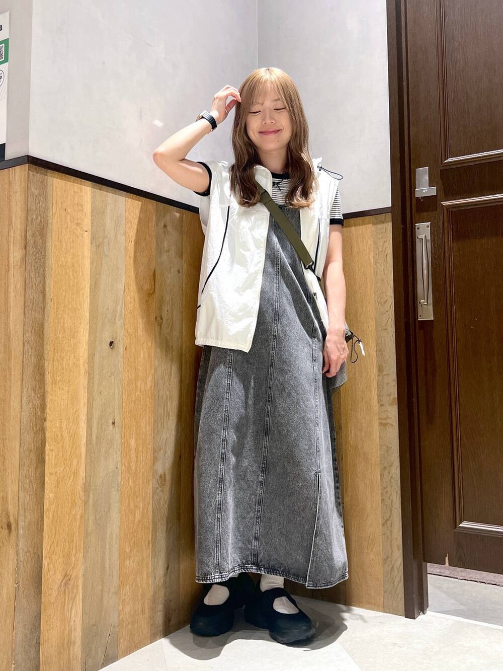 ブラック系のスニーカー、ホワイト系のTシャツ/カットソー、グリーン系のショルダーバッグを着用したレディースの夏コーディネートの2枚目の写真