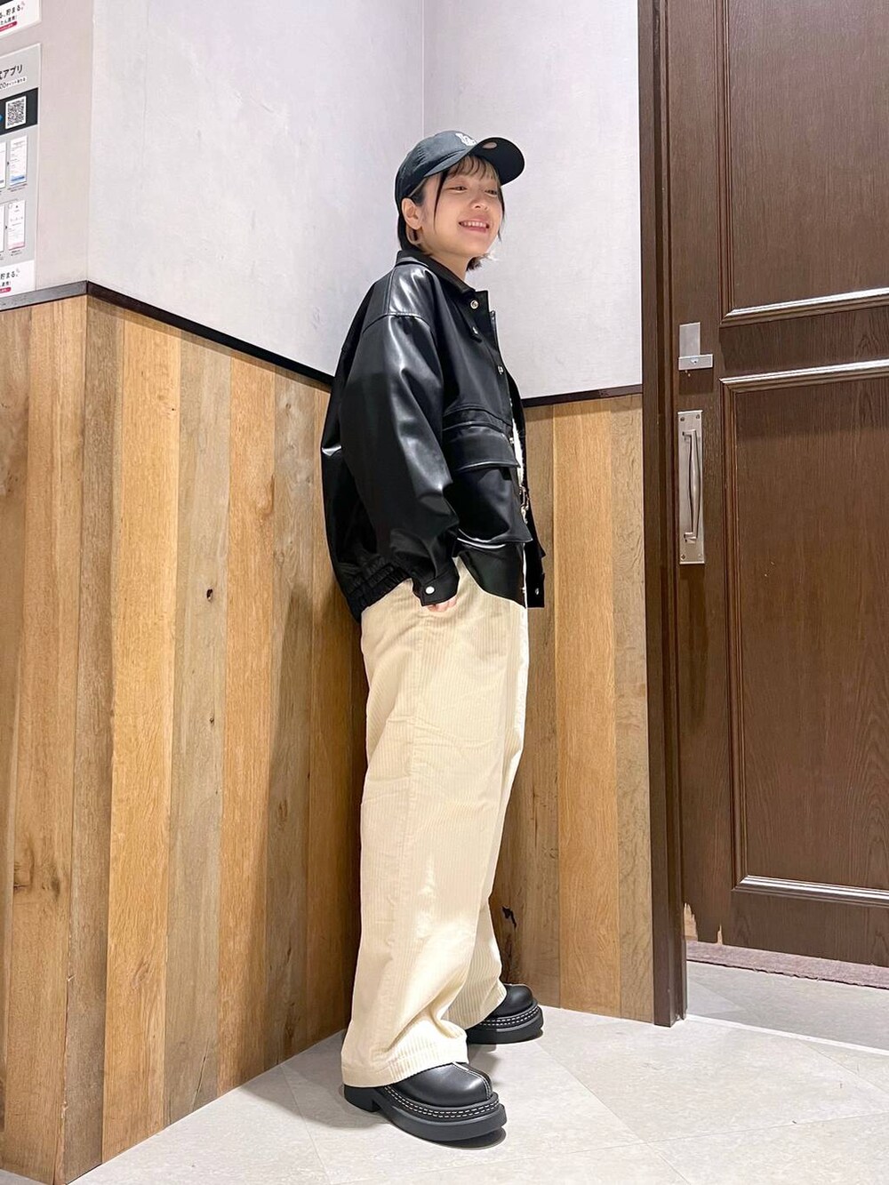 ホワイト系のスラックス、ブラック系のブルゾン、ブラック系のローファーを着用したレディースの秋コーディネートの2枚目の写真