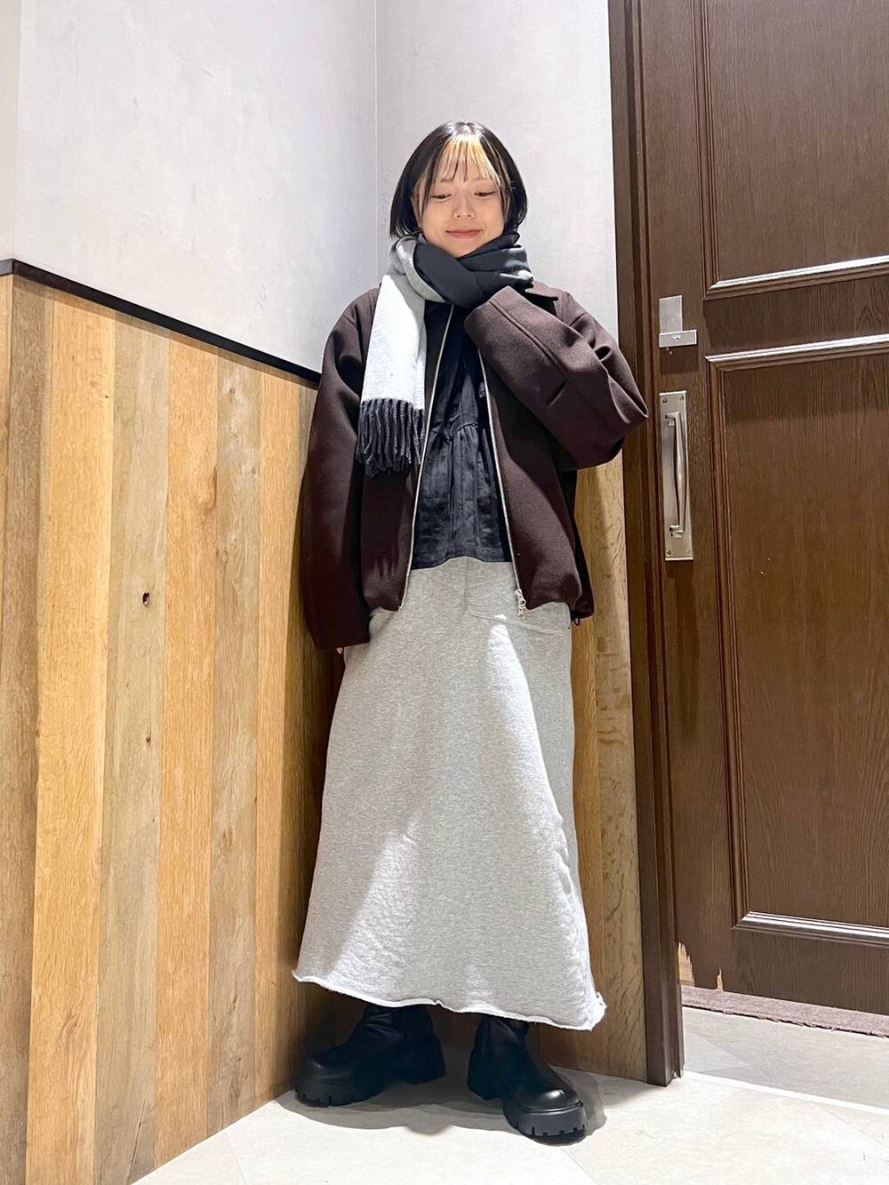 ブラウン系のブルゾン、ブラック系のブーツ、ブラック系のシャツ/ブラウスを着用したレディースの秋コーディネートの4枚目の写真