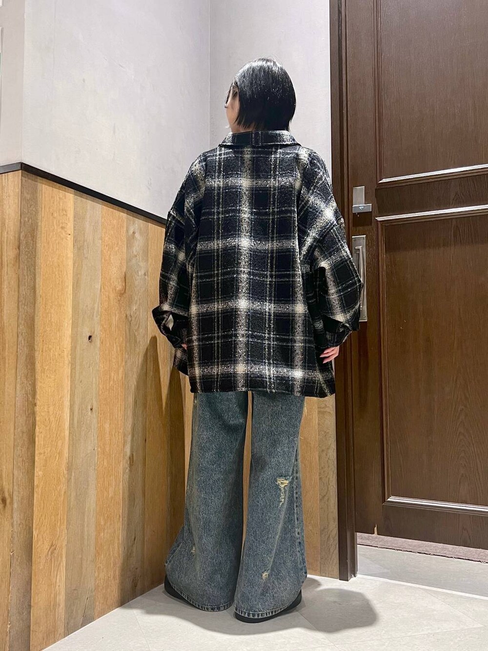 ブルー系のデニムパンツ、ブラック系のローファー、ブラック系のシャツ/ブラウスを着用したレディースの秋コーディネートの4枚目の写真