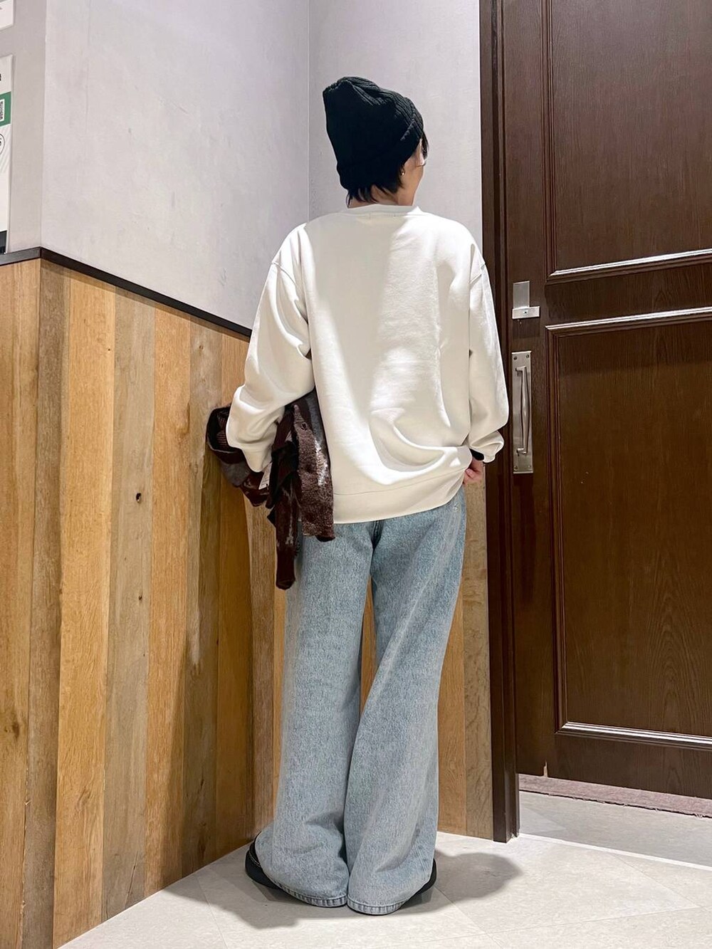 ブラウン系のカーディガン/ボレロ、ブルー系のデニムパンツ、ブラック系のローファーを着用したレディースの秋コーディネートの6枚目の写真