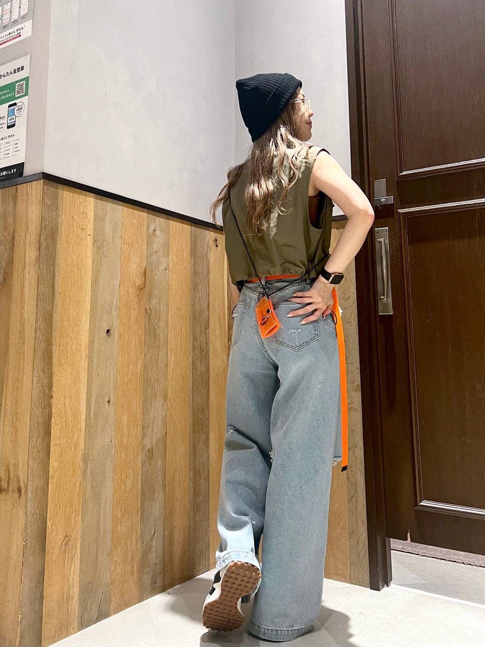 ブルー系のデニムパンツ、ブラック系のキャミソール、グリーン系のベストを着用したレディースの夏コーディネートの3枚目の写真