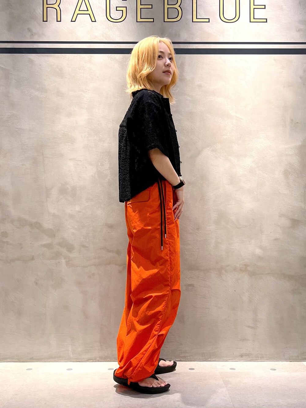 ブラック系のシャツ/ブラウス、ホワイト系のキャミソール、オレンジ系のカーゴパンツを着用したレディースの夏コーディネートの4枚目の写真