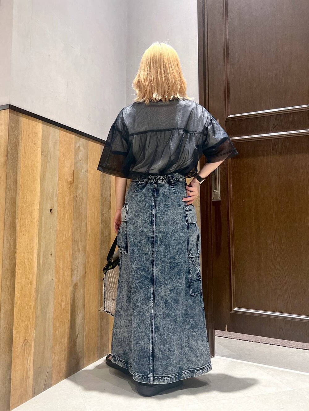 ブラック系のサンダル、ホワイト系のTシャツ/カットソー、ブルー系のデニムスカートを着用したレディースの夏コーディネートの4枚目の写真