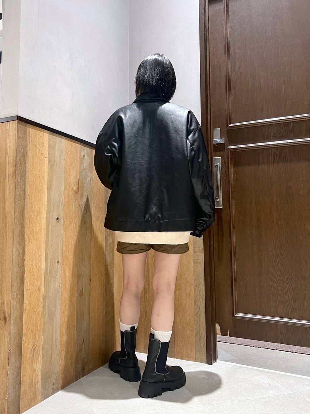 ブラック系のブーツ、ホワイト系のニット/セーター、ブラック系のブルゾンを着用したレディースの秋コーディネートの4枚目の写真