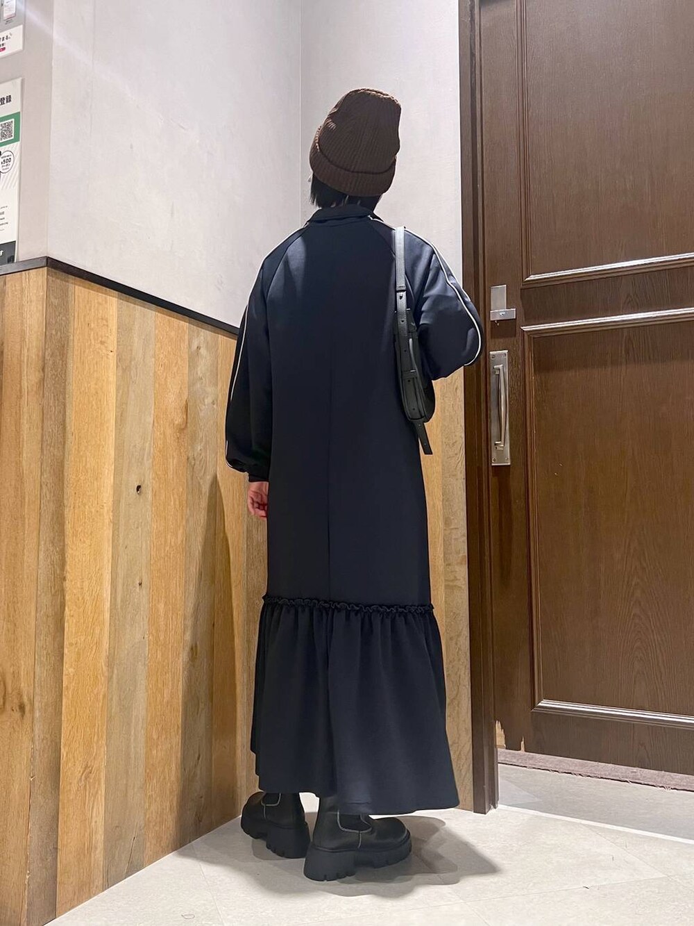 ブラック系のショルダーバッグ、ホワイト系のTシャツ/カットソー、ブラック系のブーツを着用したレディースの秋コーディネートの3枚目の写真