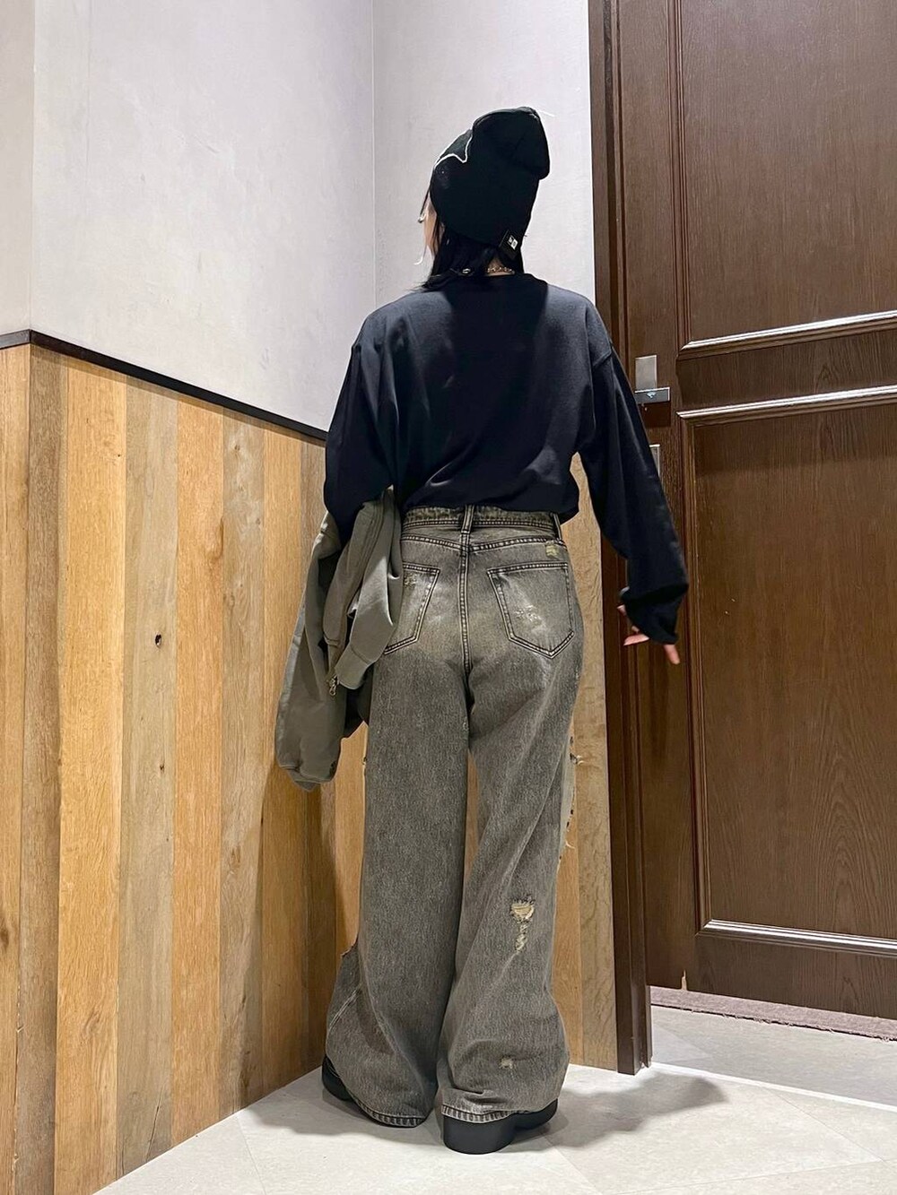 ブラック系のデニムパンツ、ブラック系のTシャツ/カットソー、グリーン系のパーカーを着用したレディースの秋コーディネートの7枚目の写真