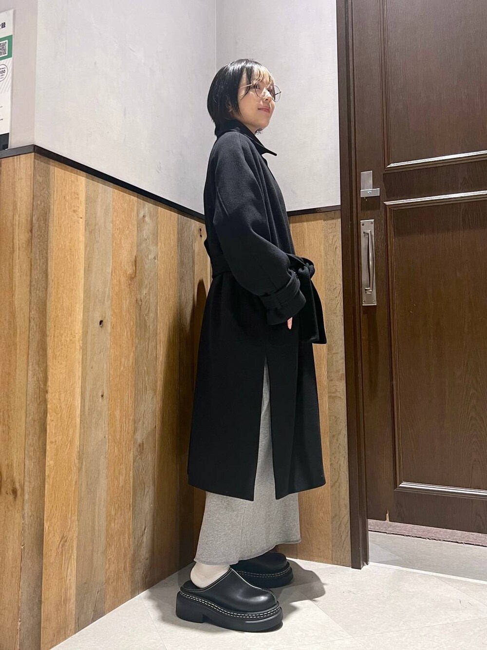 ブラック系のステンカラーコート、ブラック系のローファー、その他のスカートを着用したレディースの秋コーディネートの2枚目の写真