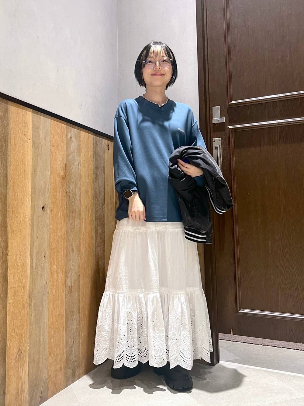 ブラック系のブーツ、ホワイト系のスカート、ブルー系のTシャツ/カットソーを着用したレディースの秋コーディネートの2枚目の写真