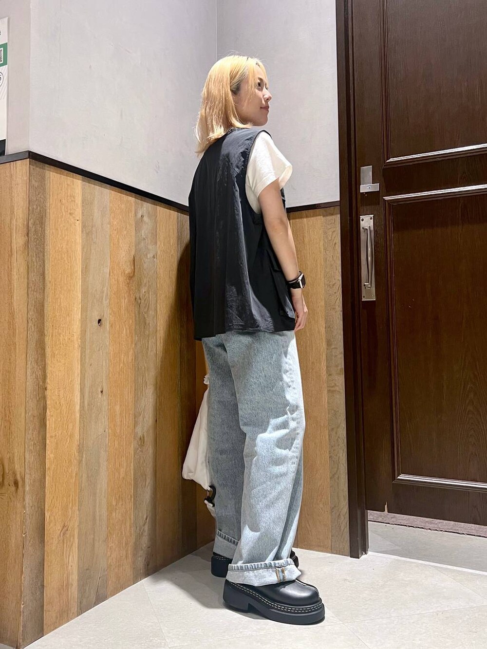 ホワイト系のショルダーバッグ、ホワイト系のTシャツ/カットソー、ブルー系のデニムパンツを着用したレディースの夏コーディネートの2枚目の写真