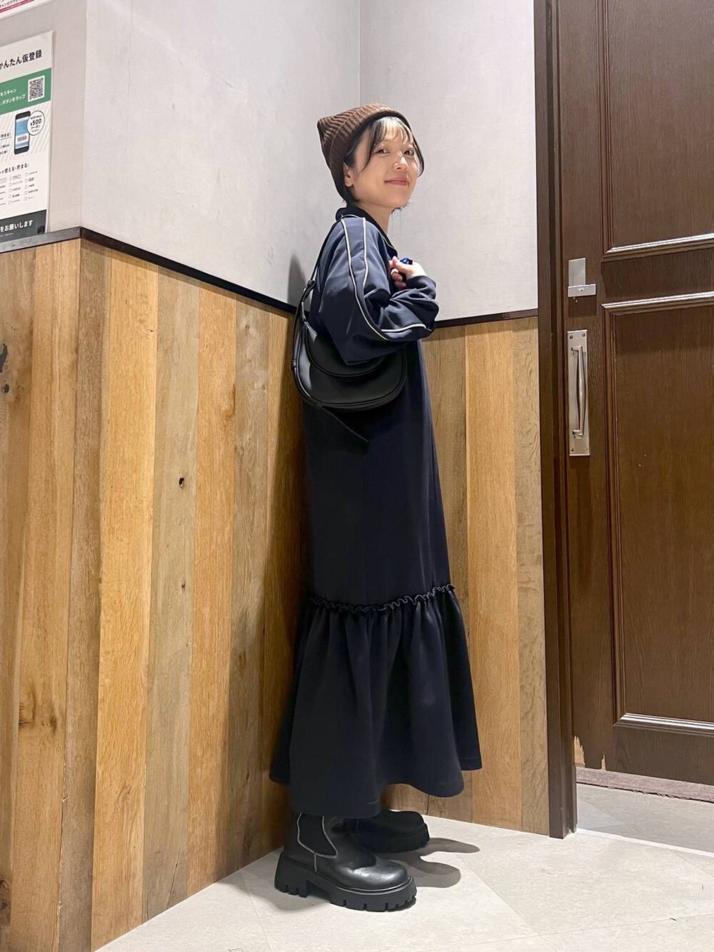 ブラック系のショルダーバッグ、ホワイト系のTシャツ/カットソー、ブラック系のブーツを着用したレディースの秋コーディネートの2枚目の写真