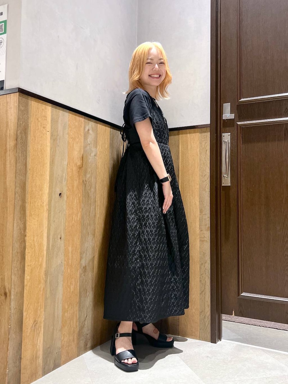 ブラック系のサンダル、ブラック系のワンピース、ブラック系のTシャツ/カットソーを着用したレディースの夏コーディネートの2枚目の写真