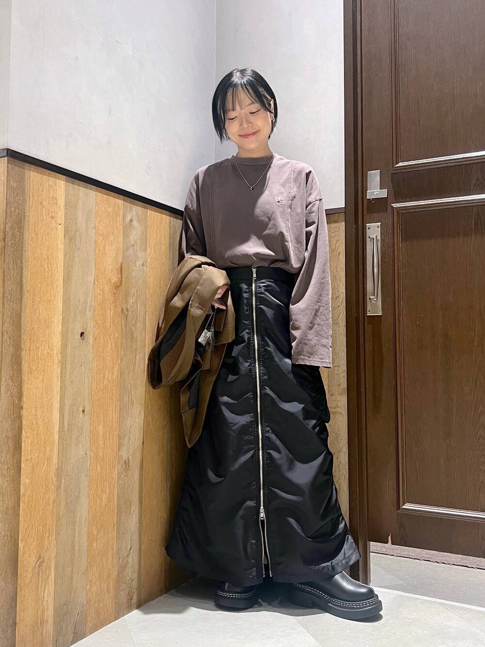 ブラック系のショルダーバッグ、ブラック系のスカート、ブラック系のローファーを着用したレディースの秋コーディネートの4枚目の写真