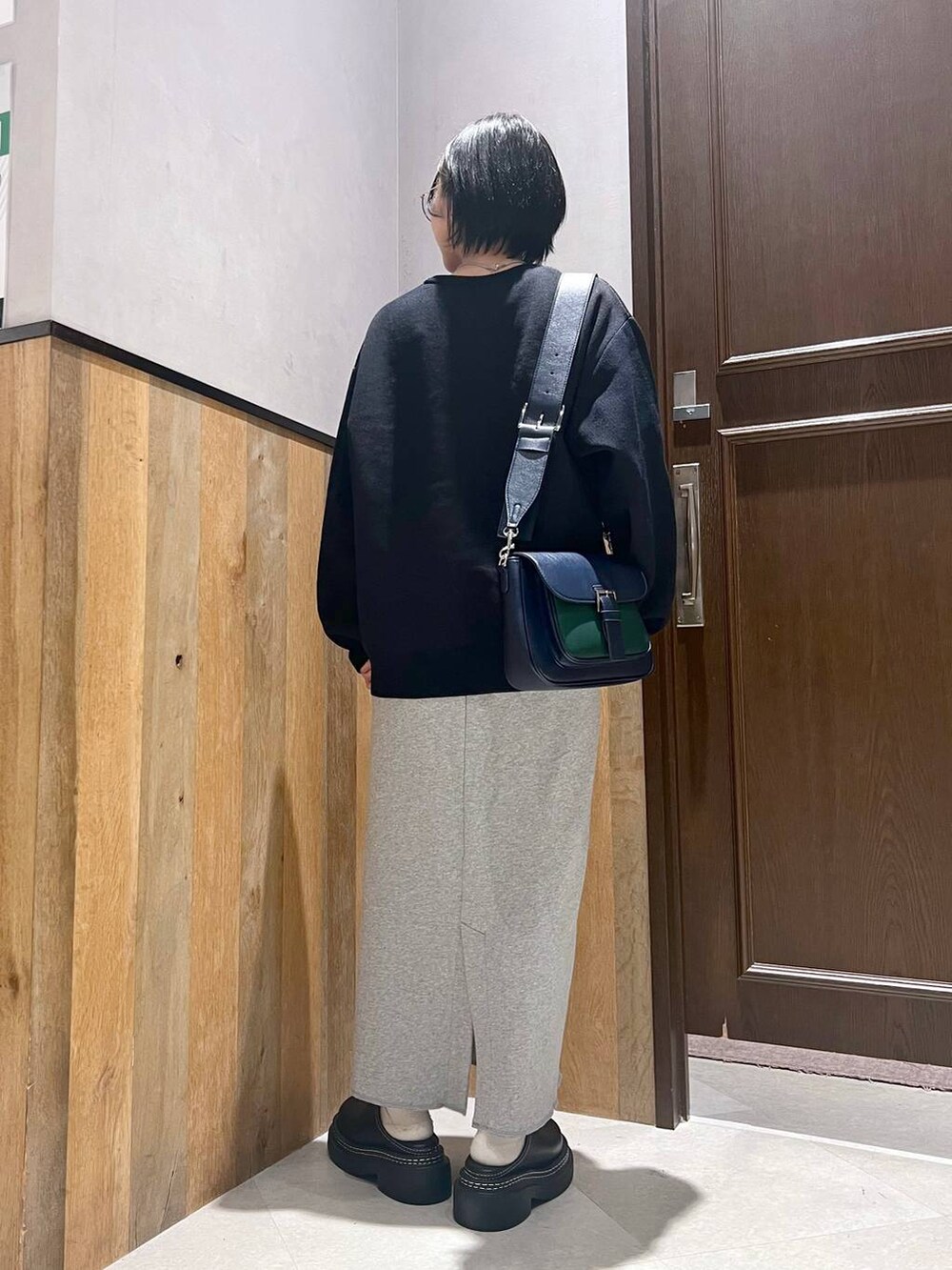 ブラック系のステンカラーコート、ブラック系のローファー、その他のスカートを着用したレディースの秋コーディネートの10枚目の写真