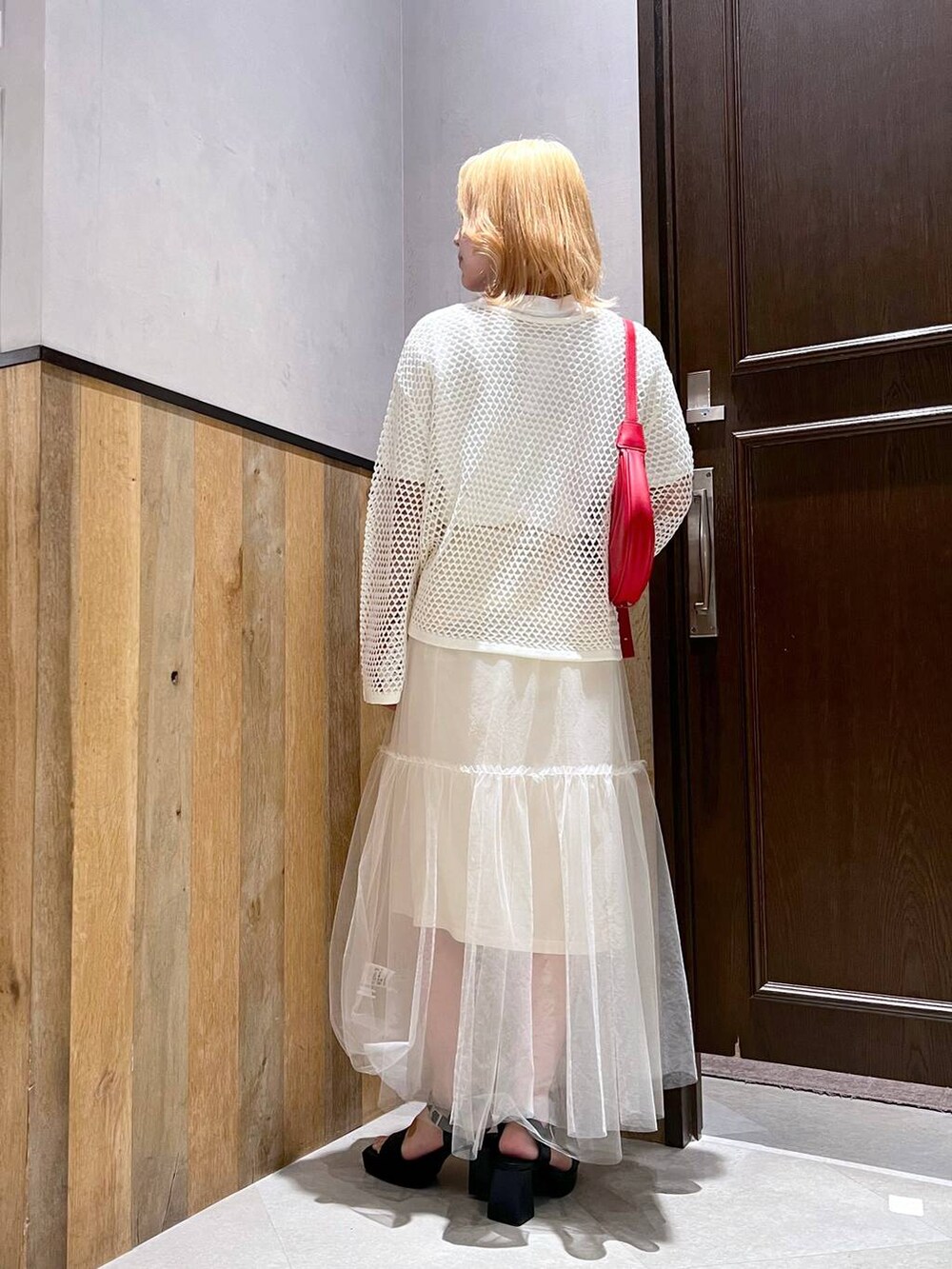 ブラック系のサンダル、ホワイト系のスカート、ホワイト系のカーディガン/ボレロを着用したレディースの夏コーディネートの2枚目の写真