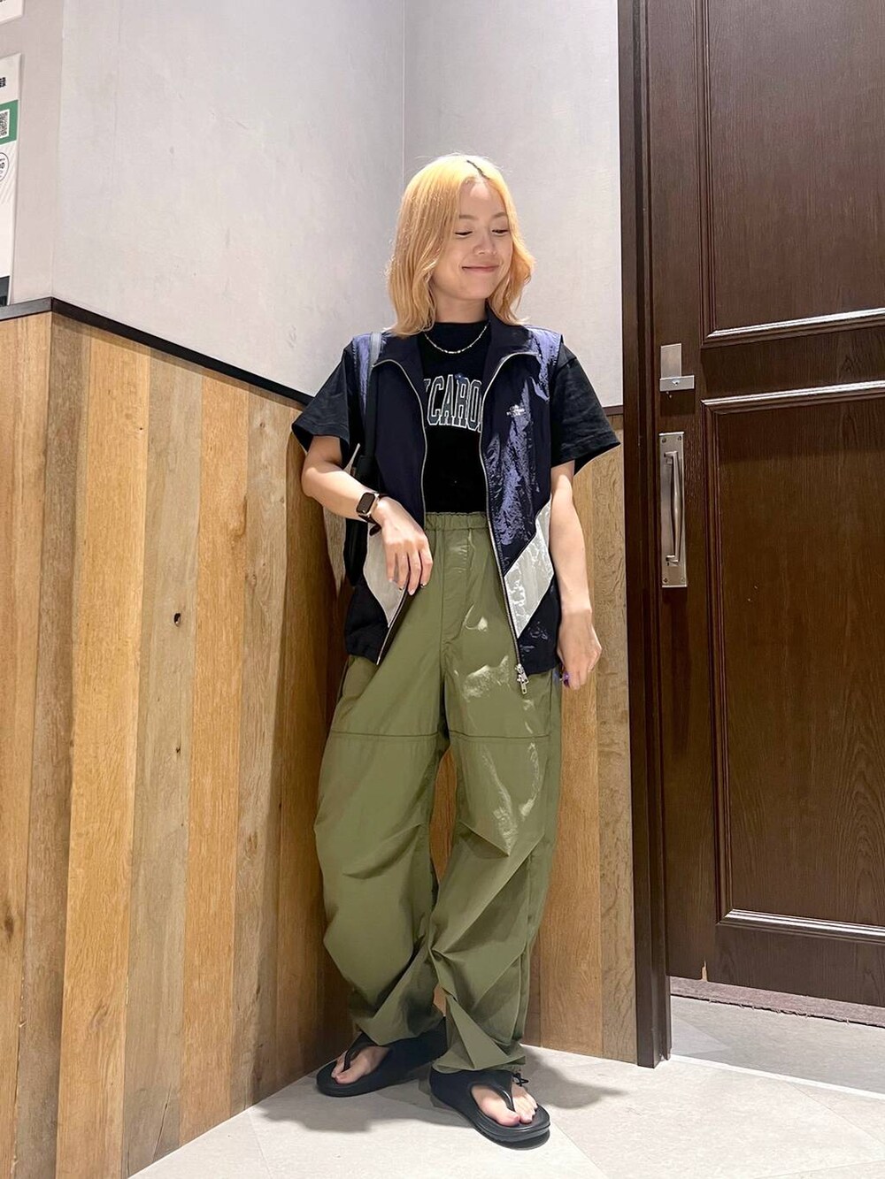 ブラック系のサンダル、ブルー系のベスト、グリーン系のカーゴパンツを着用したレディースの夏コーディネートの2枚目の写真