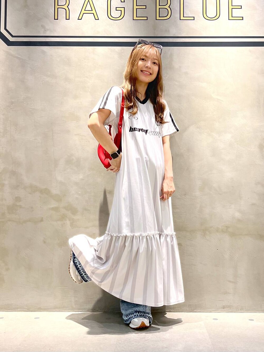 ホワイト系のワンピース、ブルー系のデニムパンツ、ホワイト系のスニーカーを着用したレディースの夏コーディネートの2枚目の写真