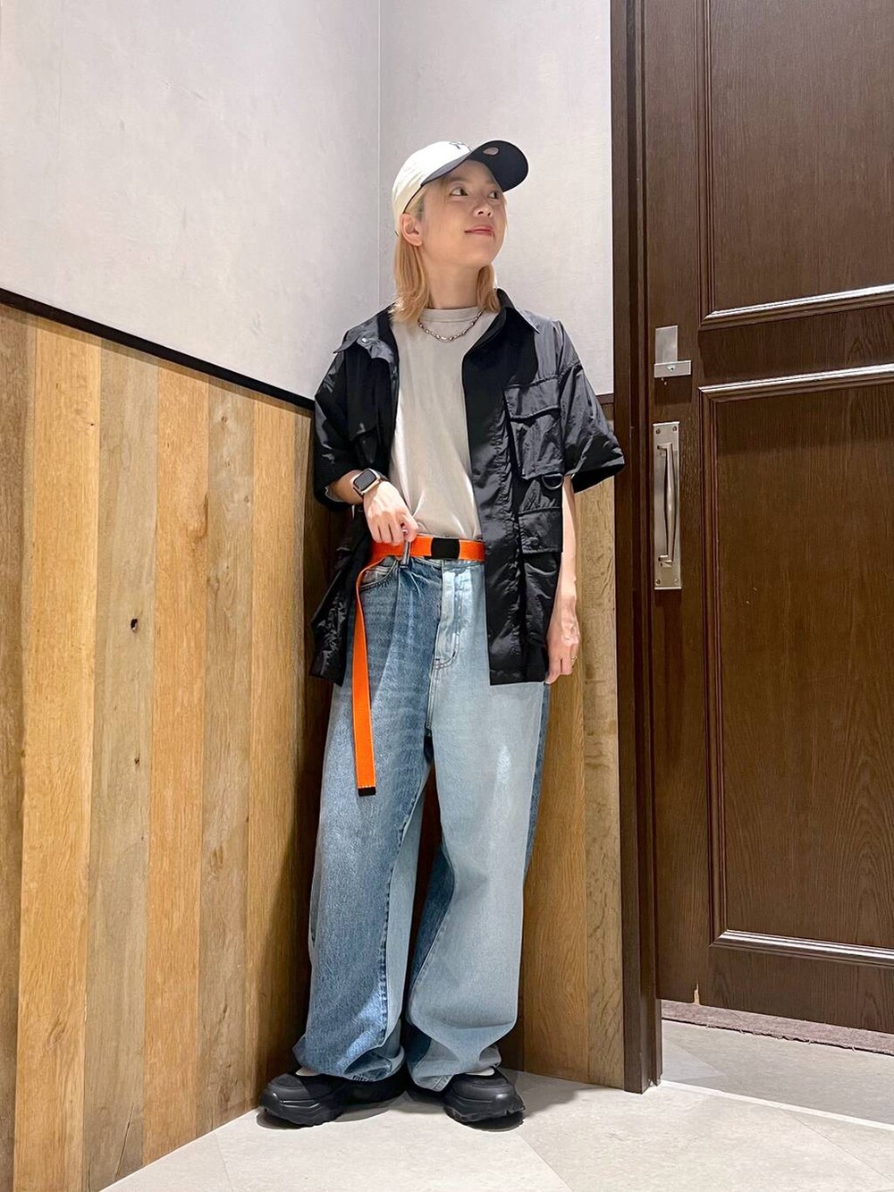 ブラック系のスニーカー、ブルー系のデニムパンツ、ブラック系のシャツ/ブラウスを着用したレディースの夏コーディネートの5枚目の写真