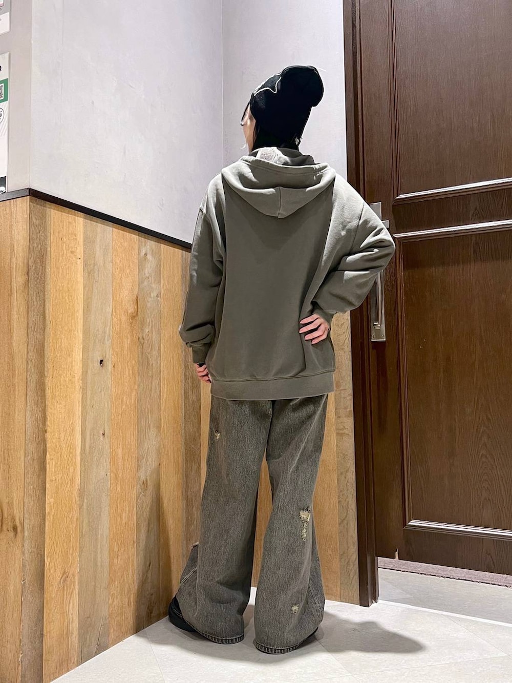 ブラック系のデニムパンツ、ブラック系のTシャツ/カットソー、グリーン系のパーカーを着用したレディースの秋コーディネートの3枚目の写真