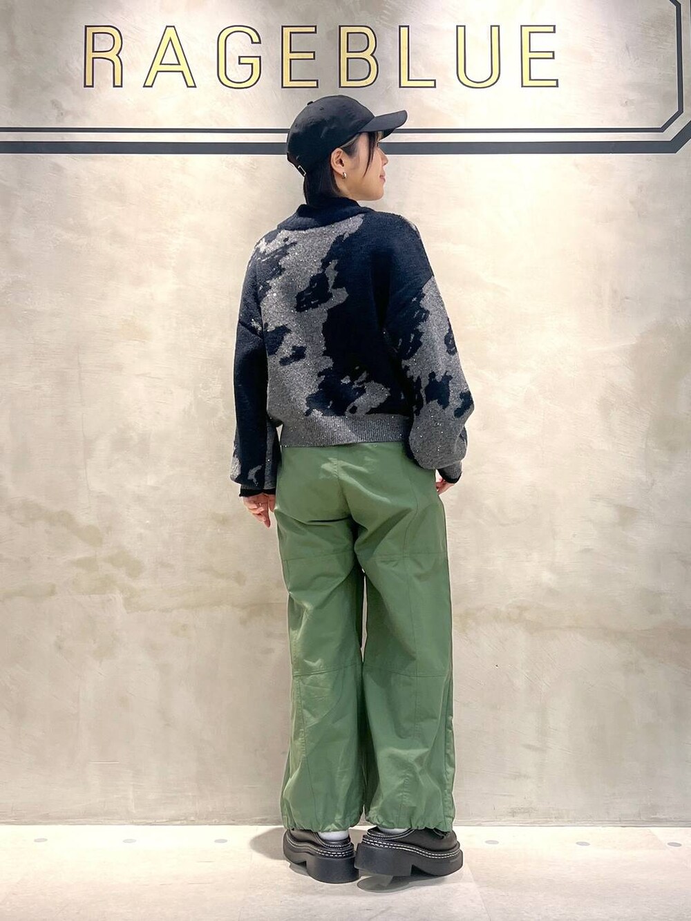 ブラック系のローファー、グリーン系のカーゴパンツ、ブラック系のニット/セーターを着用したレディースの秋コーディネートの4枚目の写真