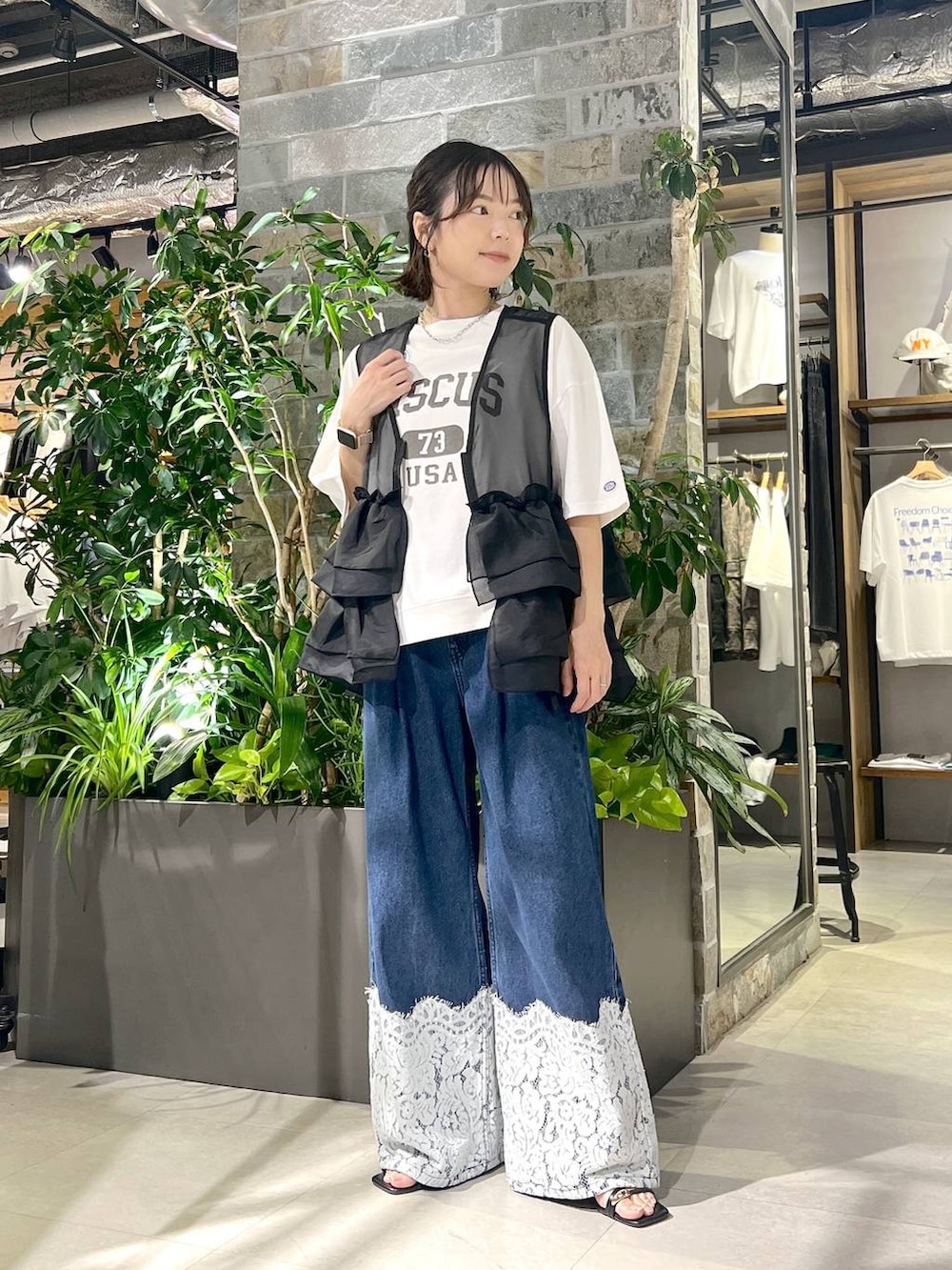 ホワイト系のTシャツ/カットソー、ブルー系のデニムパンツ、ブラック系のベストを着用したレディースの夏コーディネートの2枚目の写真