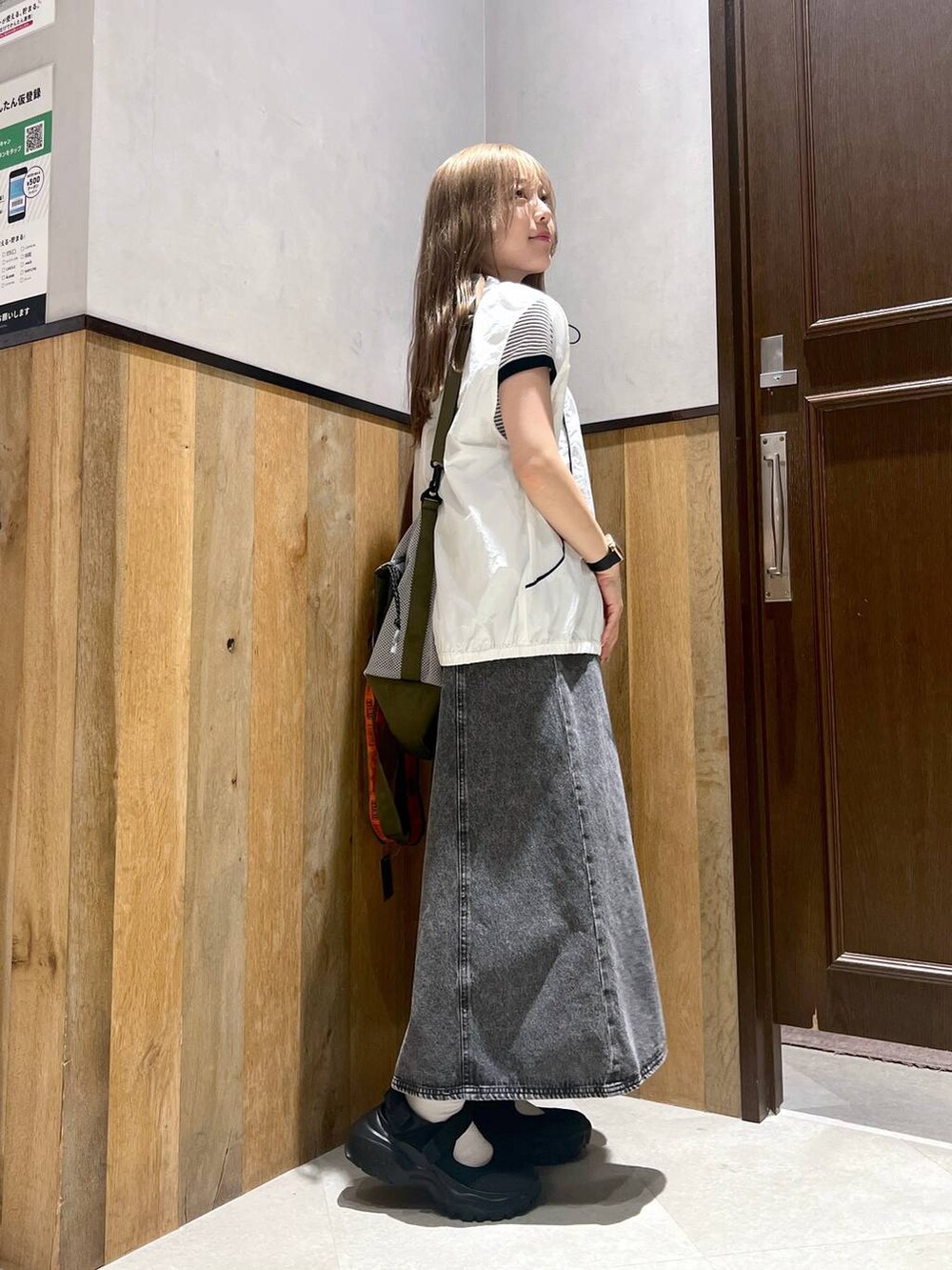 ブラック系のスニーカー、ホワイト系のTシャツ/カットソー、グリーン系のショルダーバッグを着用したレディースの夏コーディネートの3枚目の写真