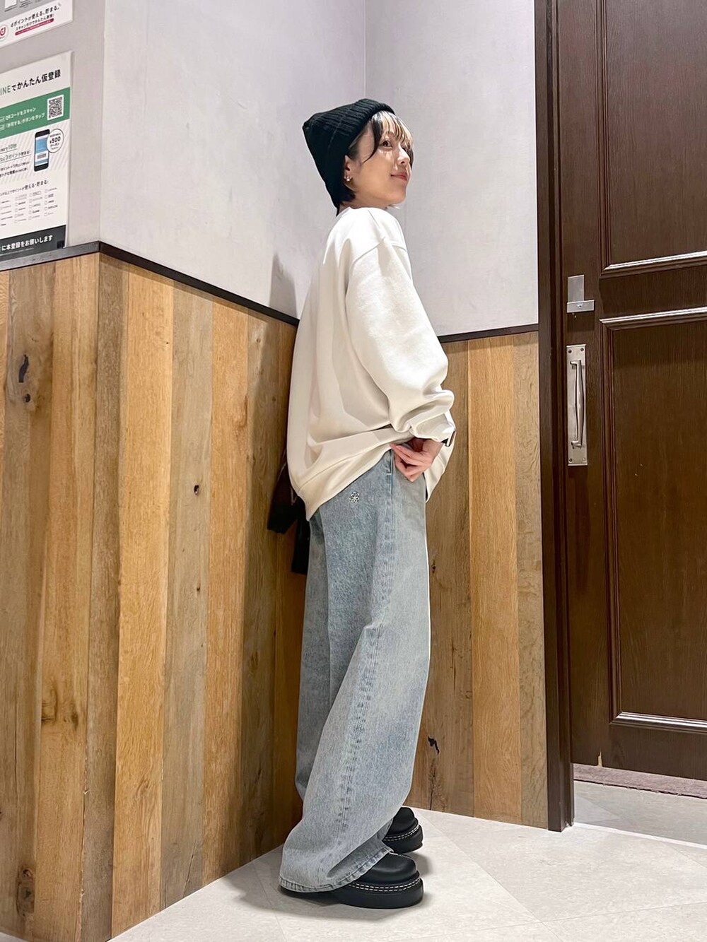 ブラウン系のカーディガン/ボレロ、ブルー系のデニムパンツ、ブラック系のローファーを着用したレディースの秋コーディネートの5枚目の写真