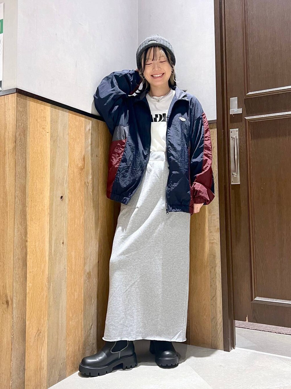 ホワイト系のTシャツ/カットソー、ブルー系のブルゾン、ブラック系のブーツを着用したレディースの秋コーディネートの5枚目の写真