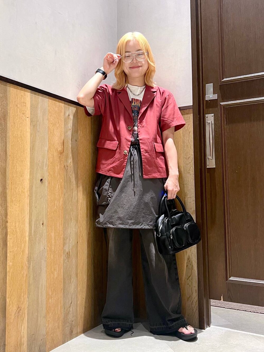 グレー系のスカート、ブラック系のデニムパンツ、レッド系のシャツ/ブラウスを着用したレディースの夏コーディネートの2枚目の写真