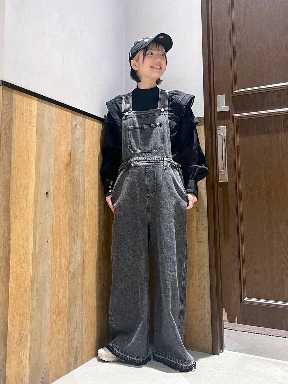 ブラック系のサロペット/オーバーオール、ブラック系のシャツ/ブラウス、グレー系のスニーカーを着用したレディースの秋コーディネートの6枚目の写真