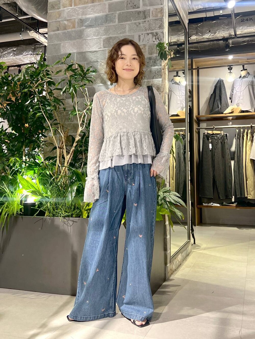 グレー系のTシャツ/カットソー、ブルー系のデニムパンツ、ブラック系のトートバッグを着用したレディースの夏コーディネートの2枚目の写真