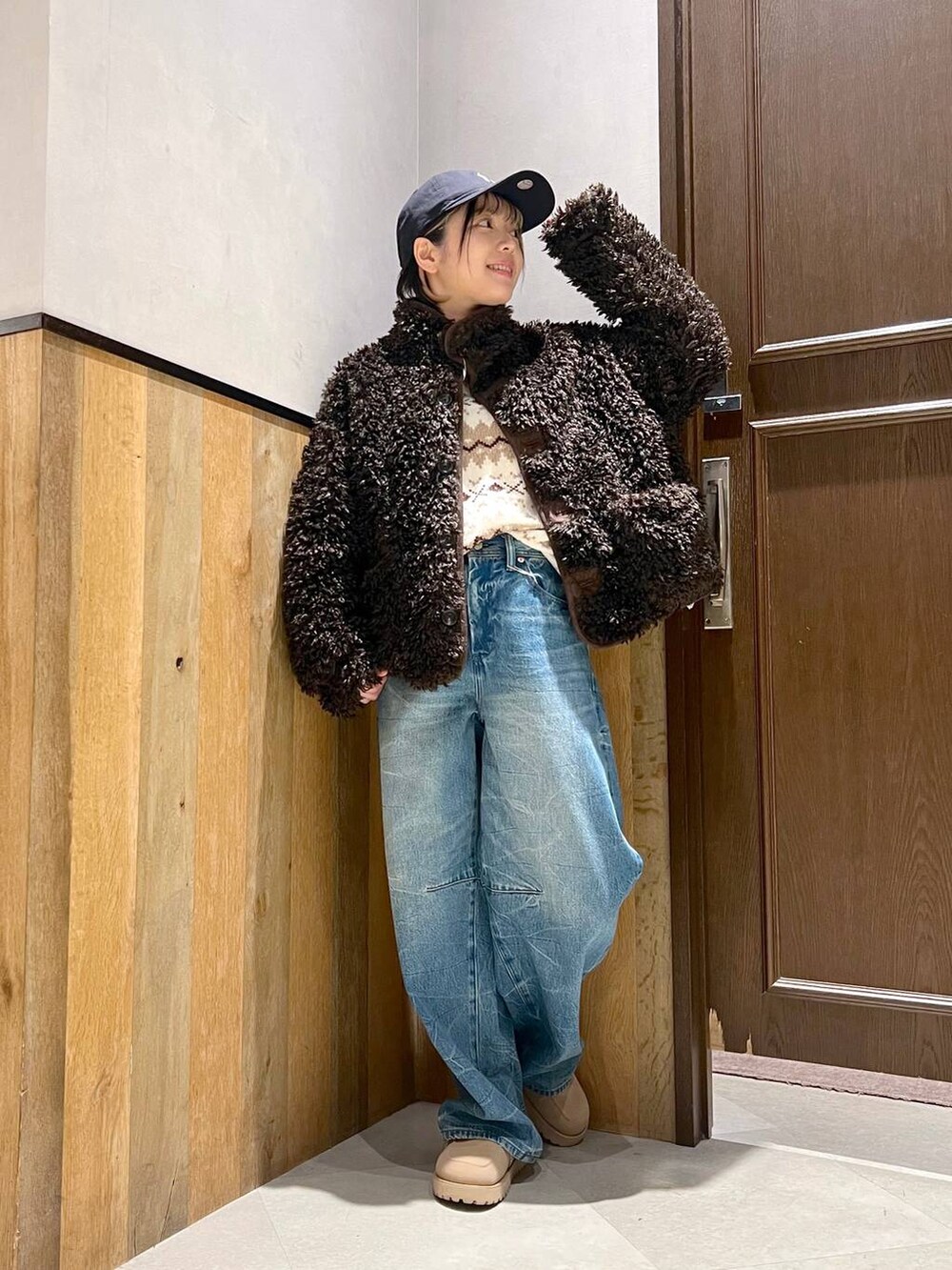 ホワイト系のニット/セーター、ブラウン系のブルゾン、ブルー系のデニムパンツを着用したレディースの秋コーディネートの8枚目の写真