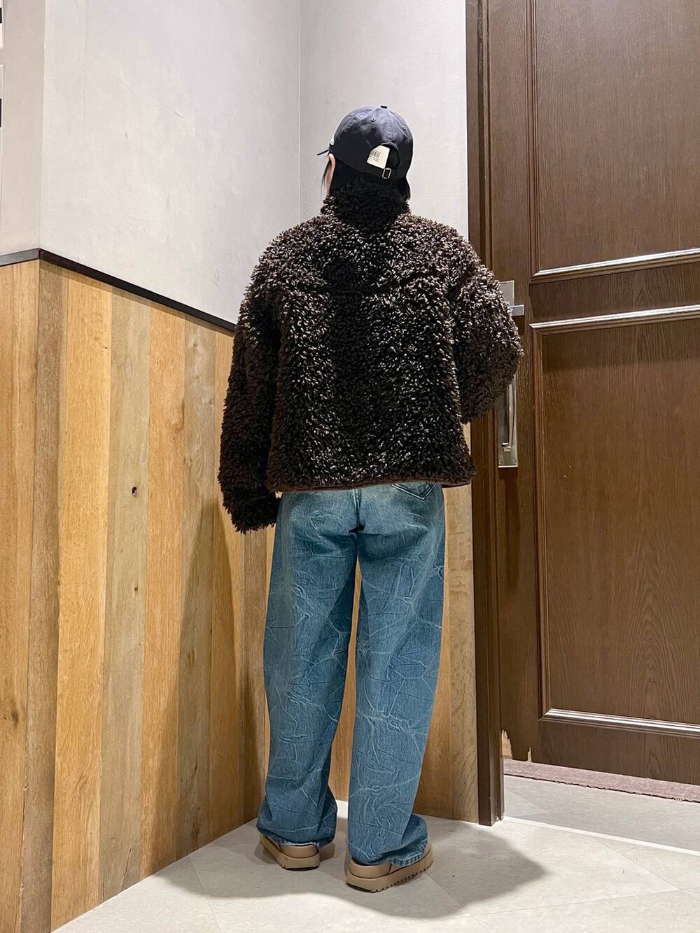 ホワイト系のニット/セーター、ブラウン系のブルゾン、ブルー系のデニムパンツを着用したレディースの秋コーディネートの7枚目の写真