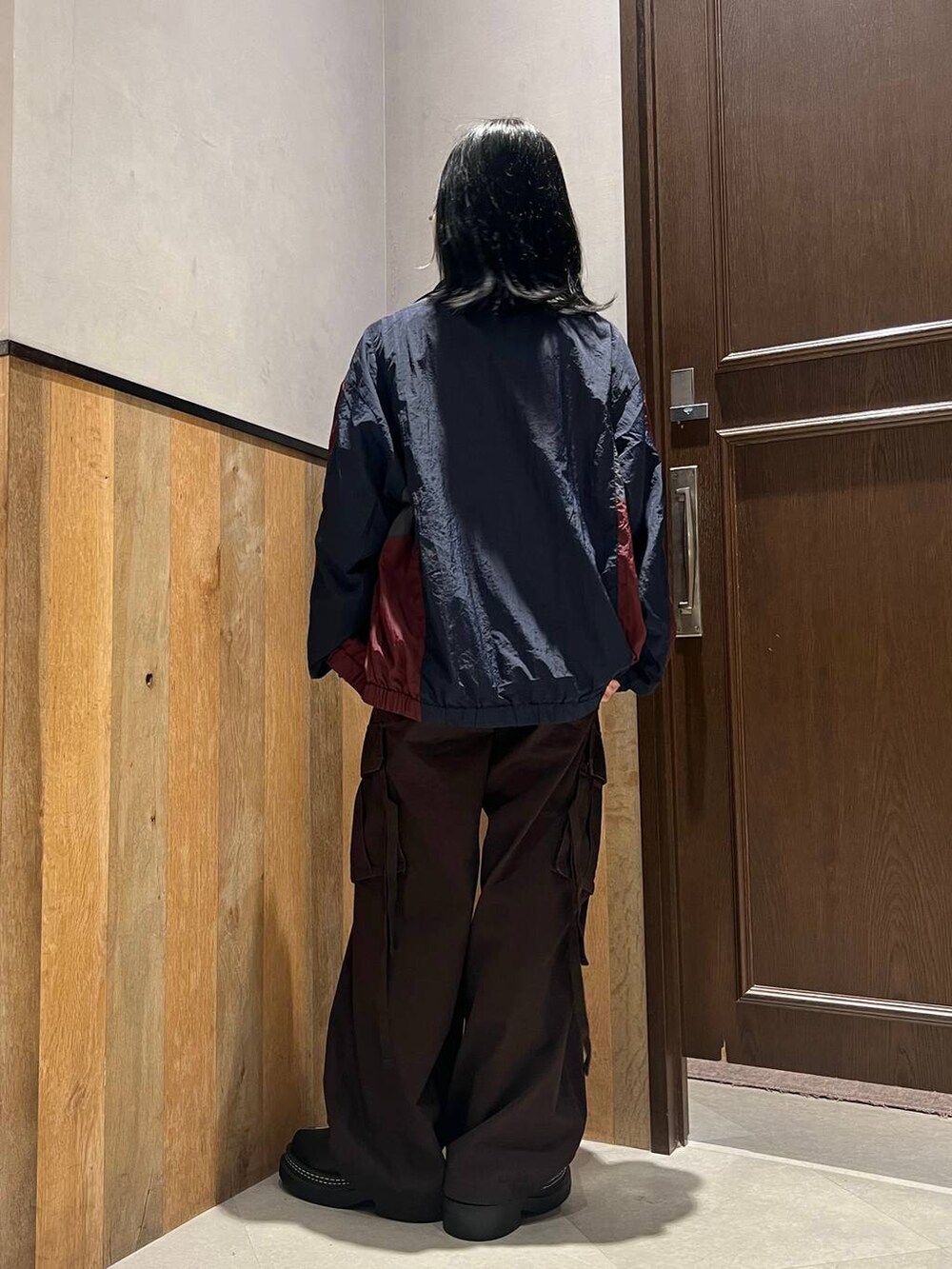 ブラウン系のカーゴパンツ、ブルー系のブルゾン、ブラック系のTシャツ/カットソーを着用したレディースの秋コーディネートの3枚目の写真