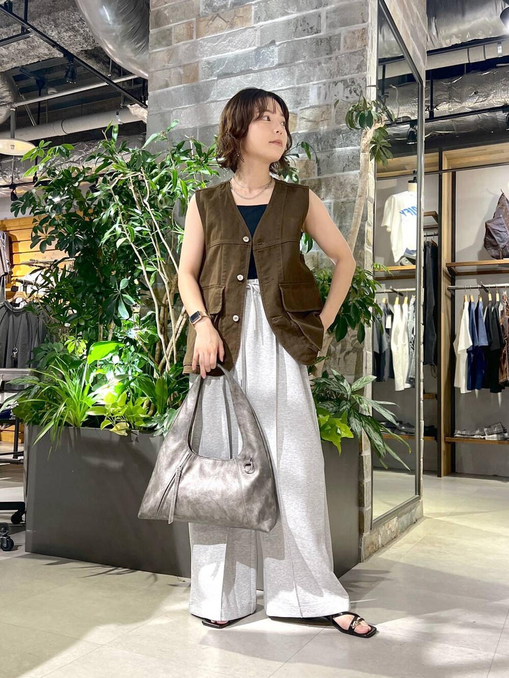 ブラック系のタンクトップ、シルバー系のトートバッグ、ブラック系のサンダルを着用したレディースの夏コーディネートの2枚目の写真