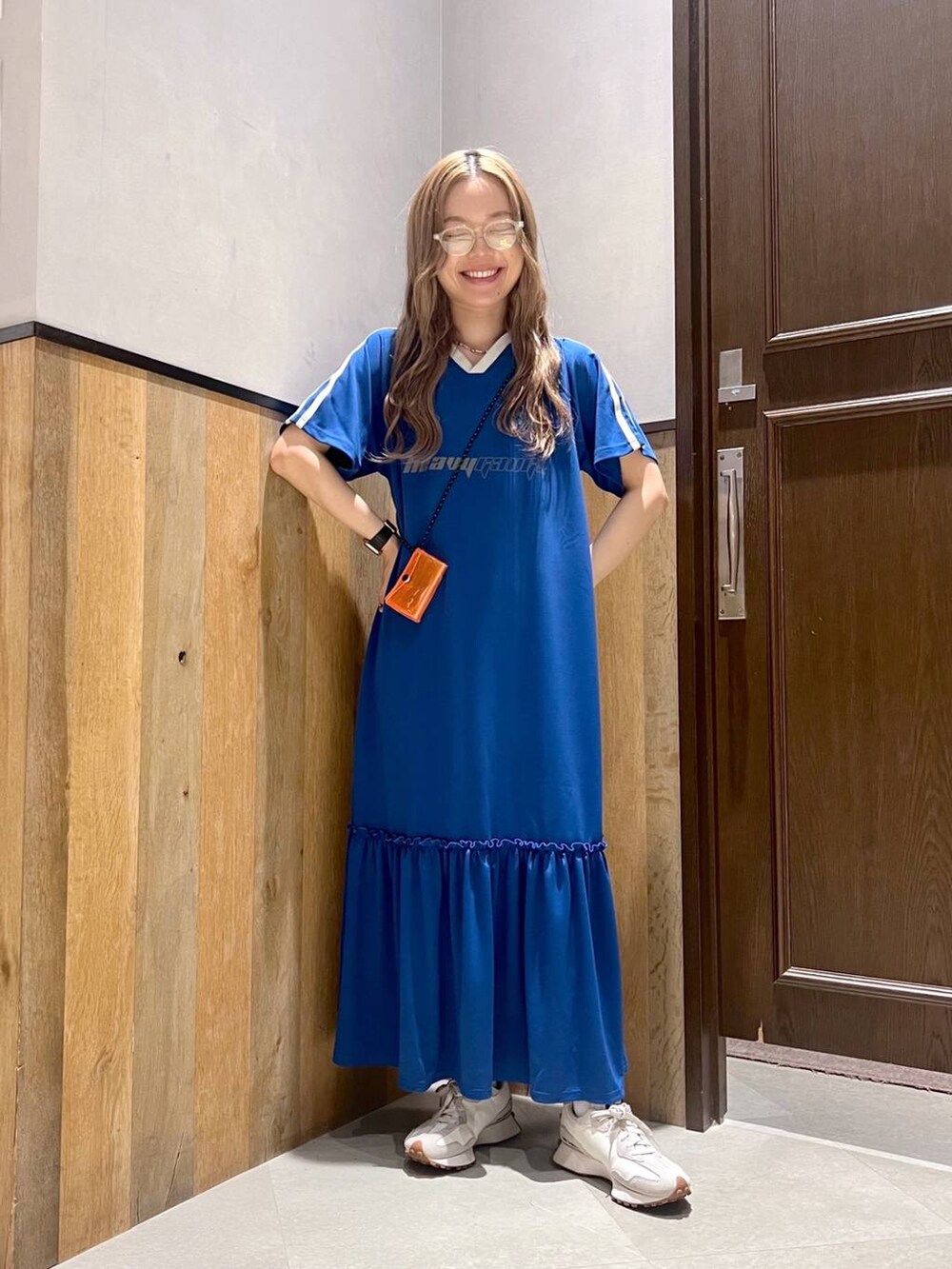 ホワイト系のワンピース、ホワイト系のスニーカー、オレンジ系のコインケースを着用したレディースの夏コーディネートの5枚目の写真