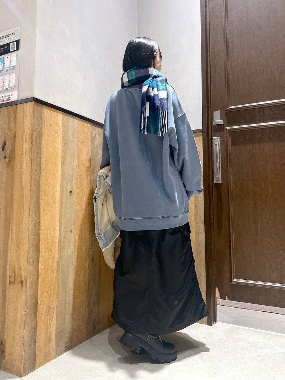 ホワイト系のブルゾン、ブラック系のブーツ、ブラック系のスカートを着用したレディースの秋コーディネートの3枚目の写真