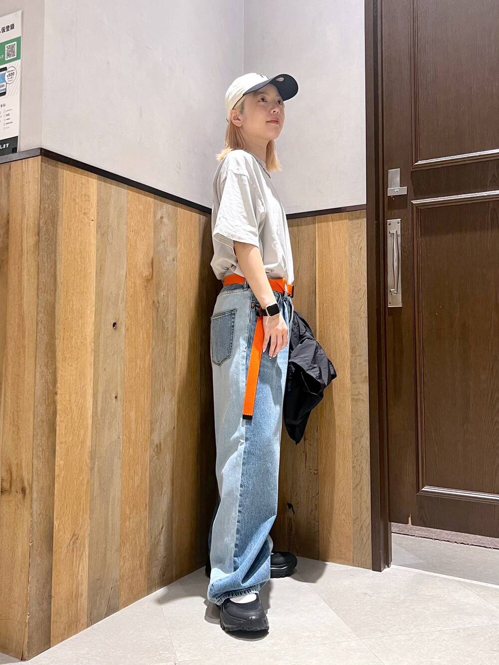 ブラック系のスニーカー、ブルー系のデニムパンツ、ブラック系のシャツ/ブラウスを着用したレディースの夏コーディネートの3枚目の写真