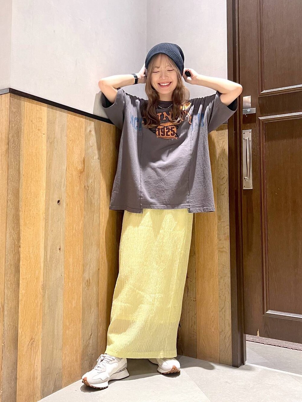 ホワイト系のスニーカー、ブラック系のTシャツ/カットソー、イエロー系のスカートを着用したレディースの夏コーディネートの4枚目の写真
