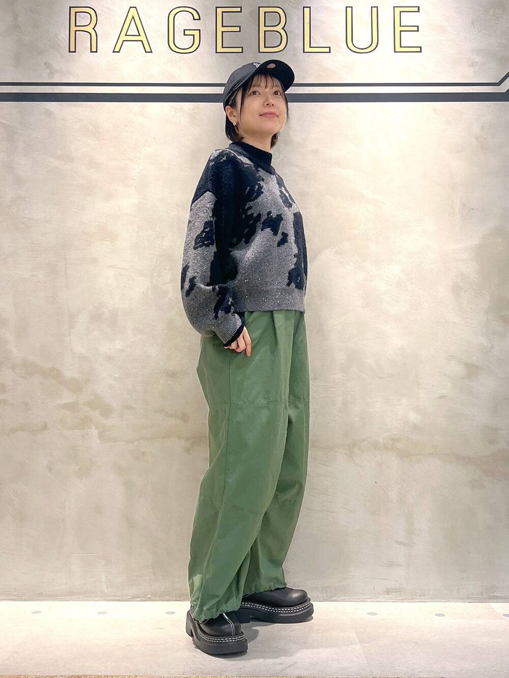 ブラック系のローファー、グリーン系のカーゴパンツ、ブラック系のニット/セーターを着用したレディースの秋コーディネートの3枚目の写真