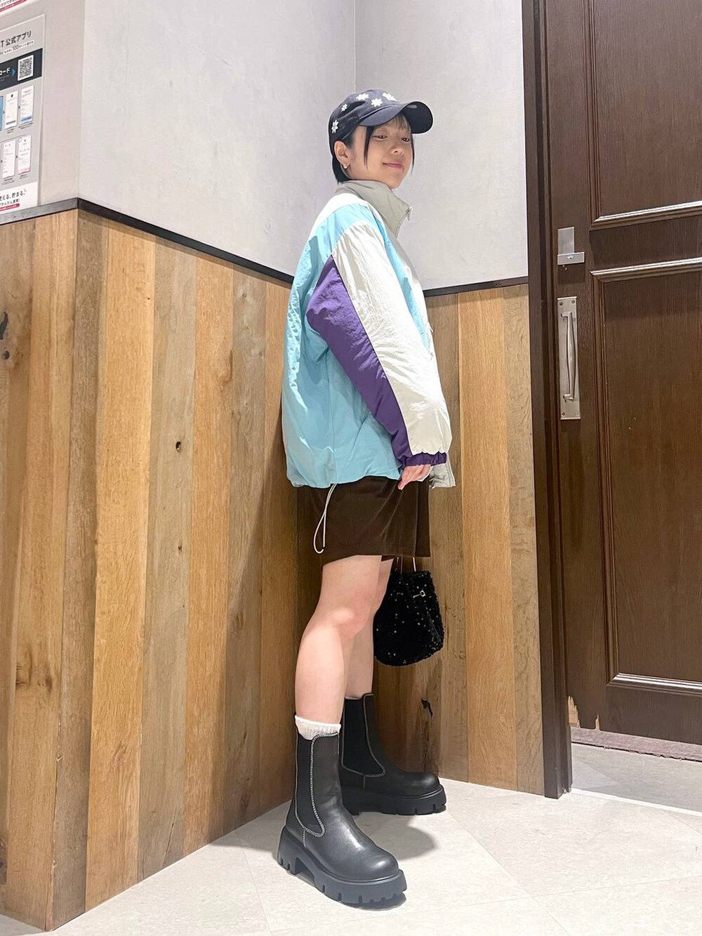 ホワイト系のダウンジャケット/コート、ブラック系のブーツ、ブラック系のハンドバッグを着用したレディースの秋コーディネートの3枚目の写真