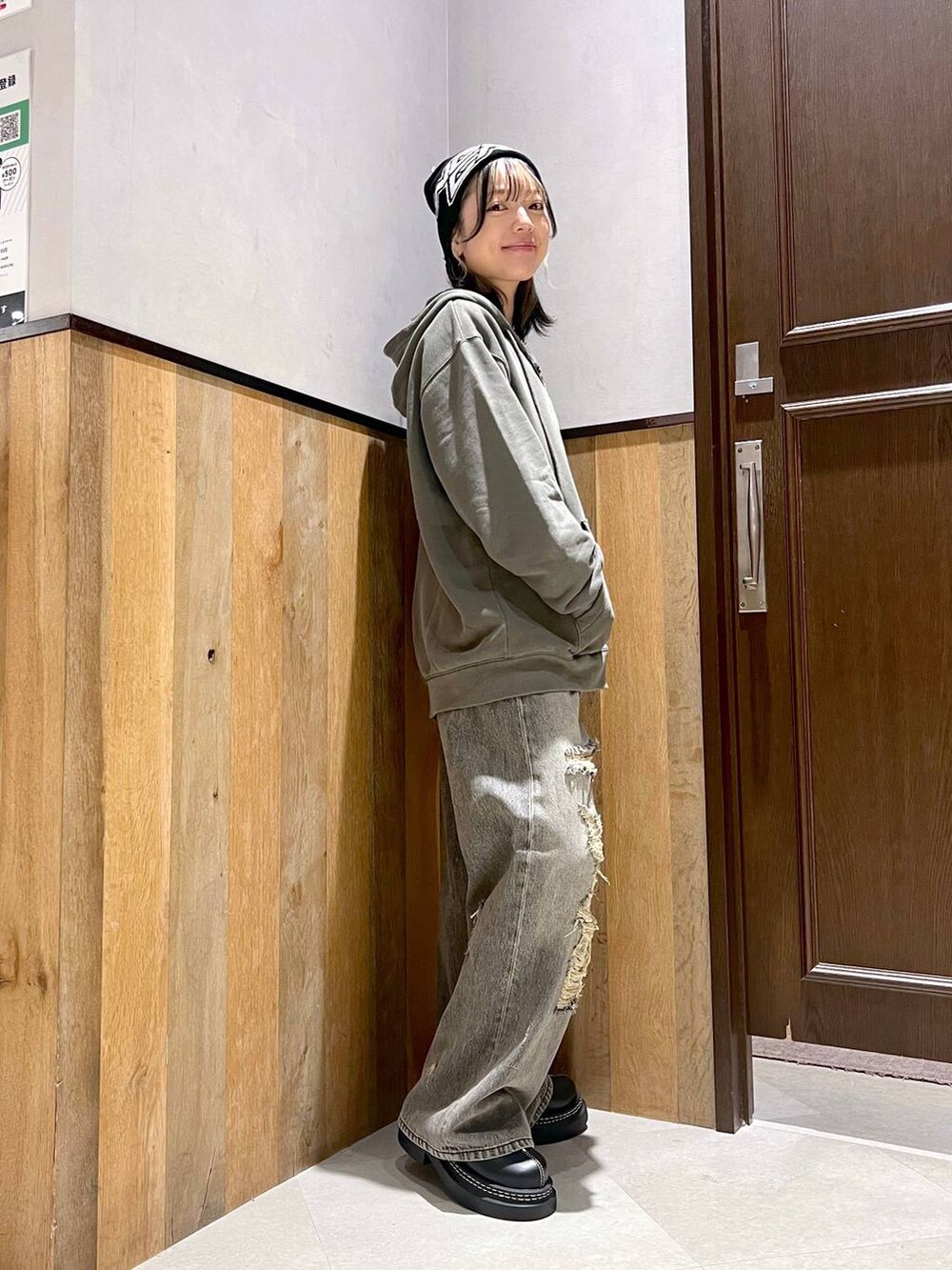 ブラック系のデニムパンツ、ブラック系のTシャツ/カットソー、グリーン系のパーカーを着用したレディースの秋コーディネートの2枚目の写真