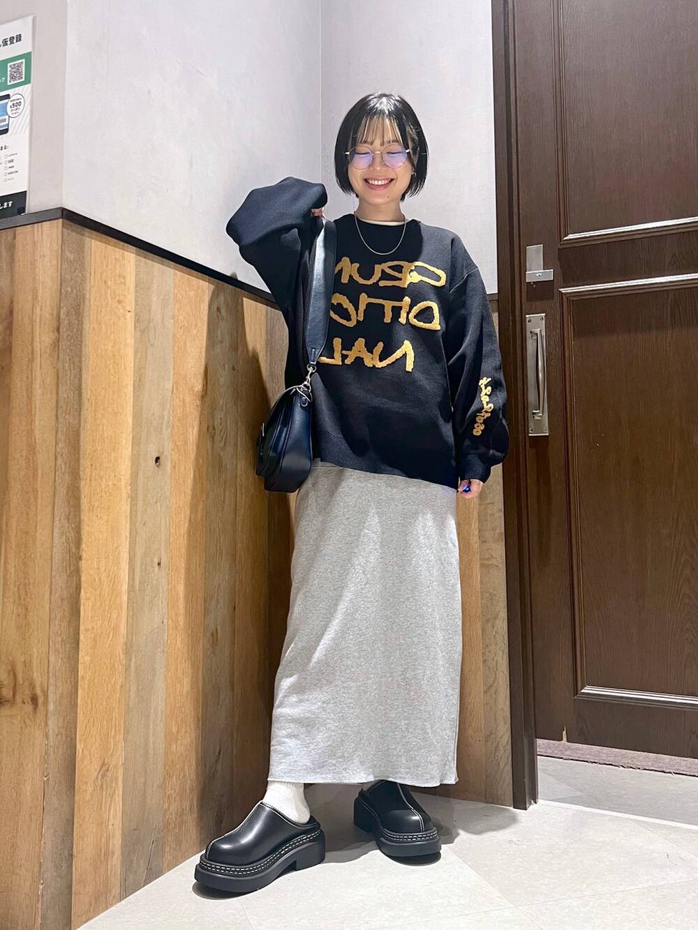 ブラック系のステンカラーコート、ブラック系のローファー、その他のスカートを着用したレディースの秋コーディネートの8枚目の写真